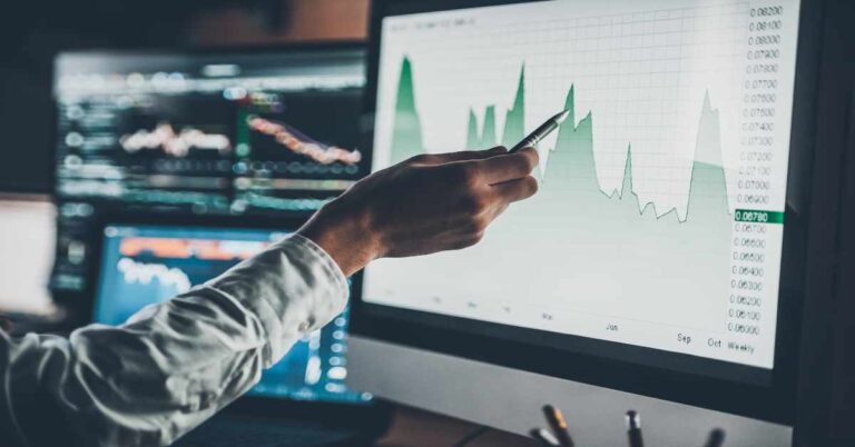 Analyzing data. Close-up of young businessman pointing on the data presented in the chart with pen while working in creative office